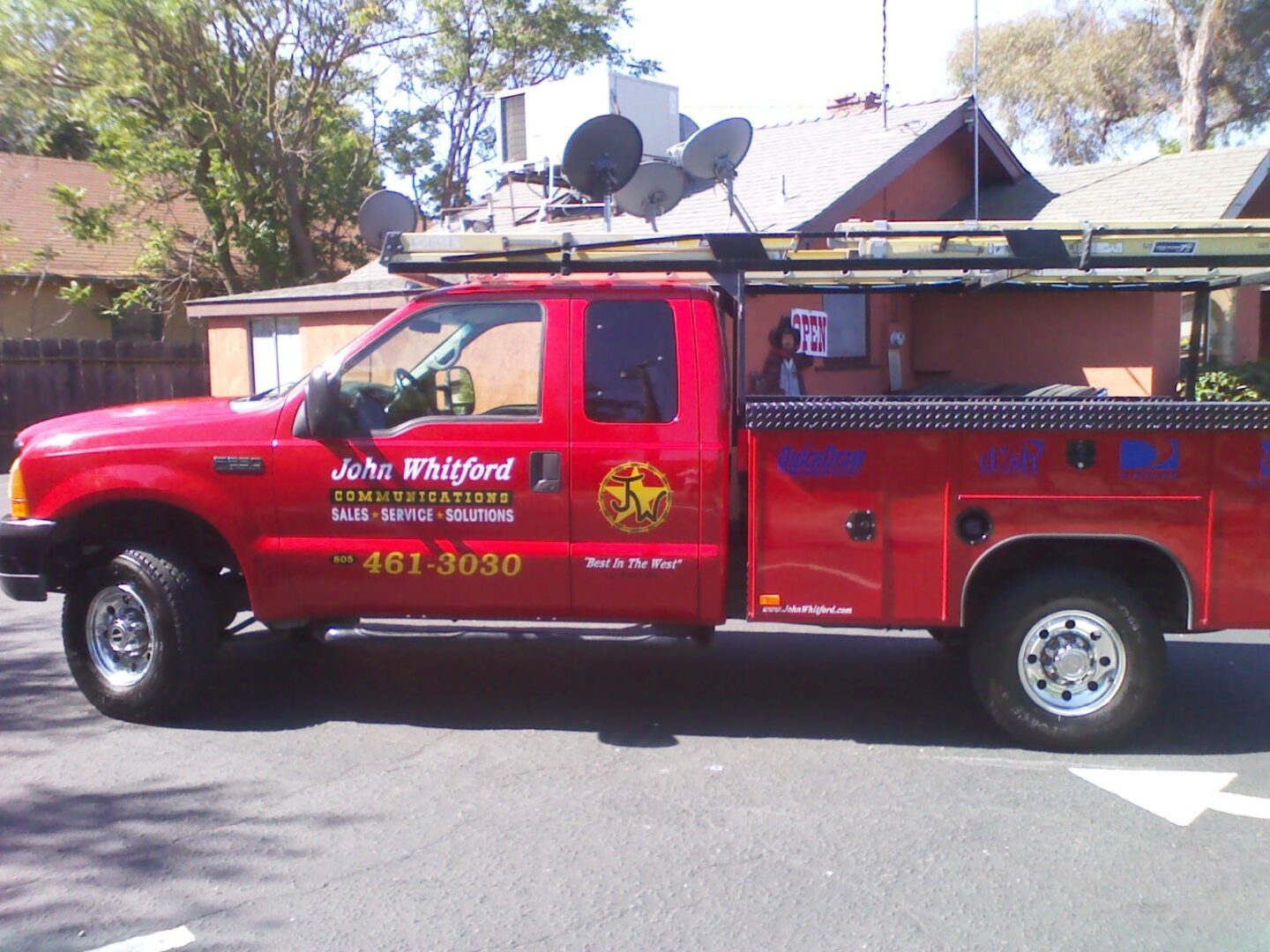 A red truck with a satellite dish on the back of it.