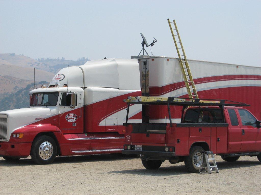 A red and white truck with ladder in the back